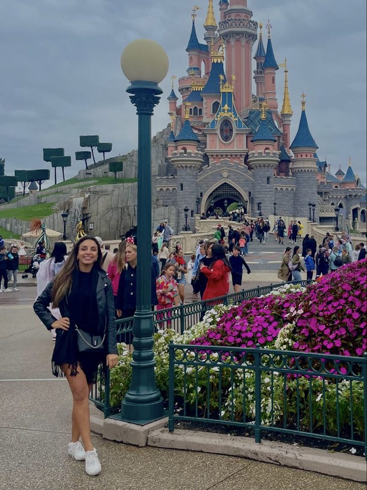 Natasha em um parque, com um castelo ao fundo